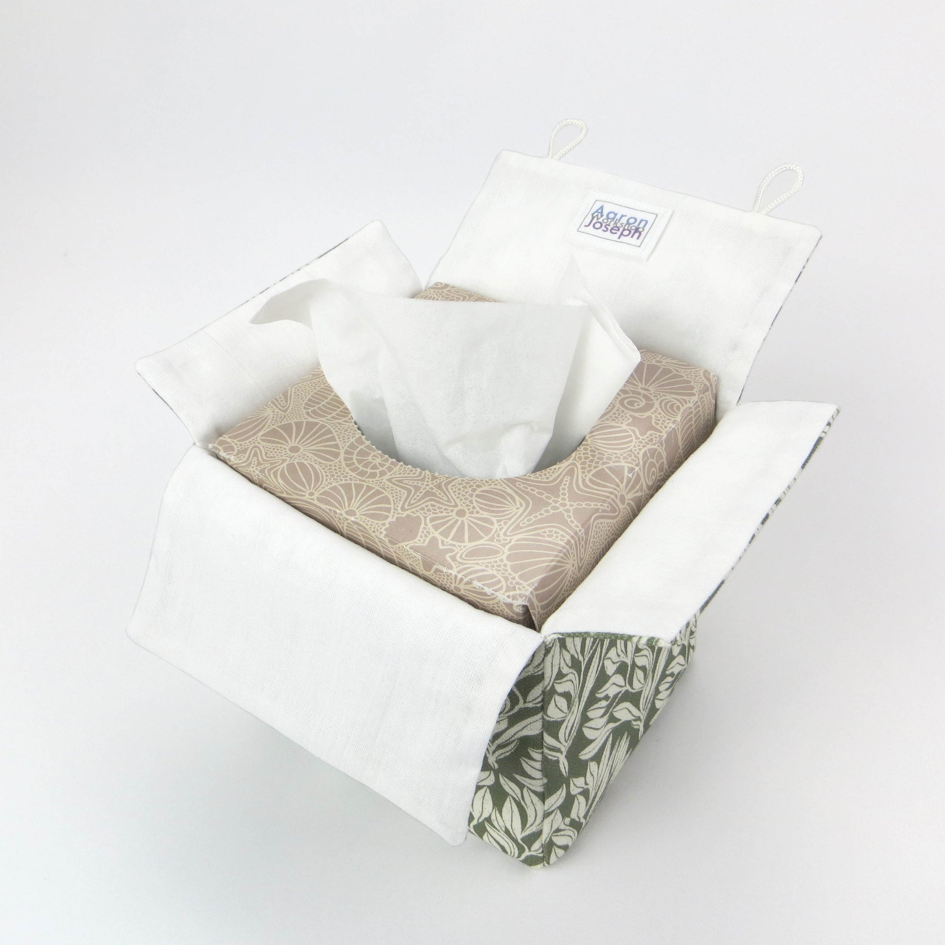 Linen square tissue box cover with an off-white leaf pattern on a sage green background