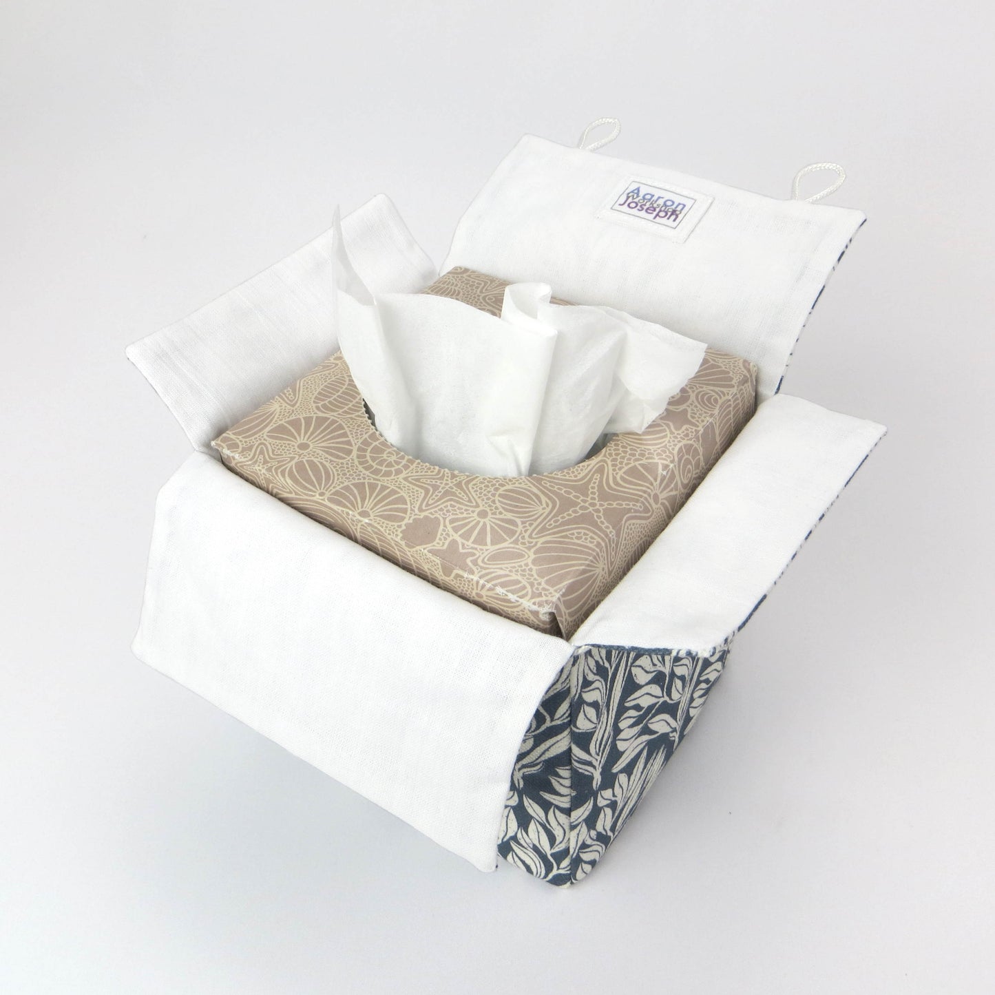 Linen square tissue box cover with an off-white leaf pattern on a blue background