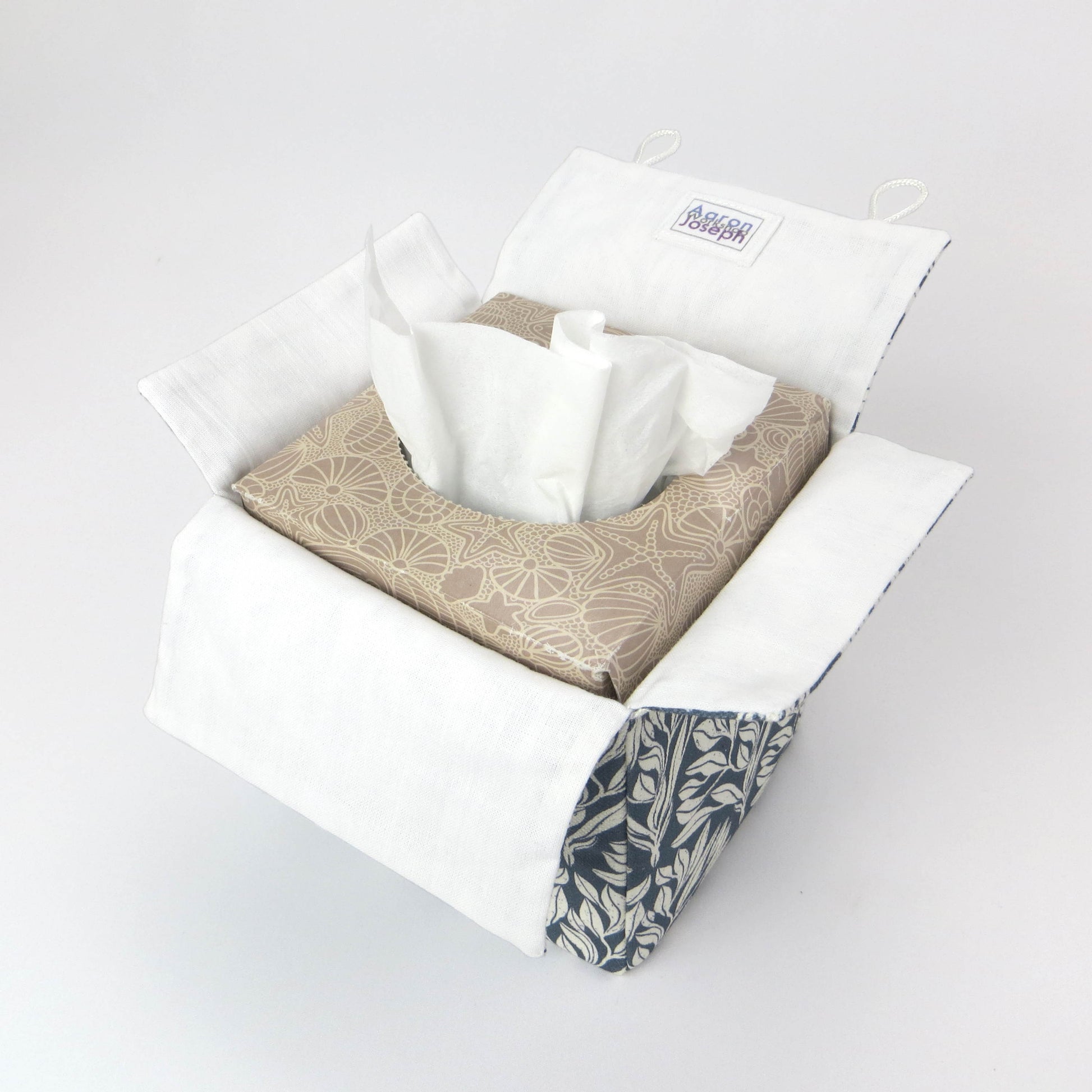 Linen square tissue box cover with an off-white leaf pattern on a blue background