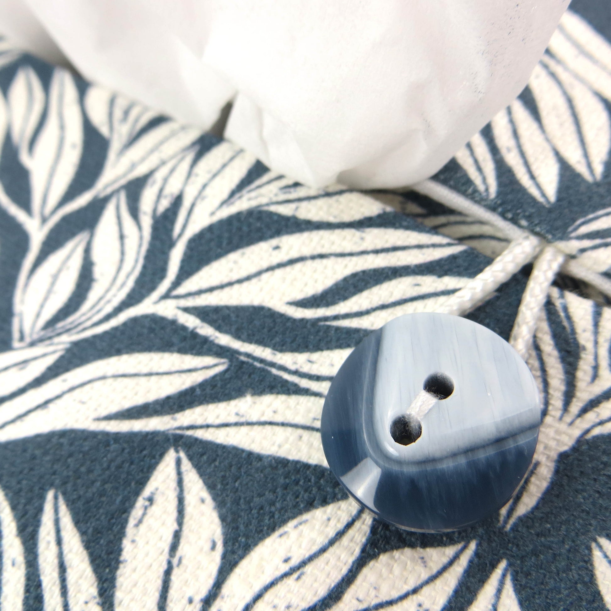 Linen rectangular tissue box cover with an off-white leaf pattern on a blue background