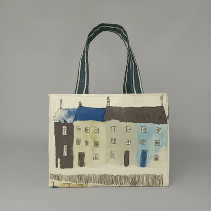 Front view of a handmade mini tote bag with seaside houses illustrated on an off-white background.