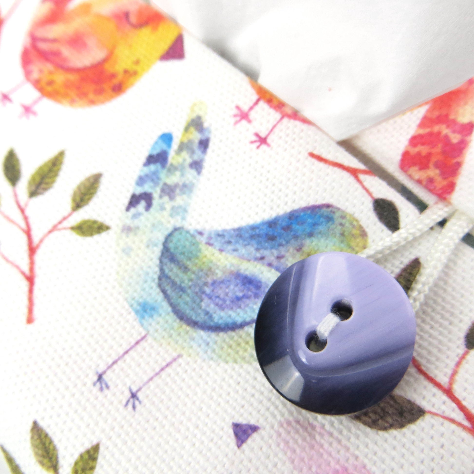 Cotton rectangle tissue box cover with watercolour style blue, purple, and orange sleeping birds on white background