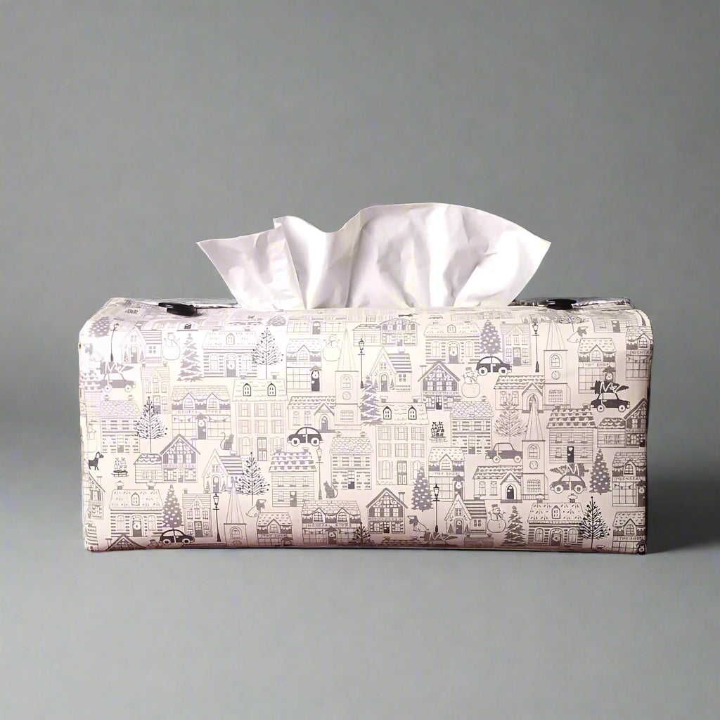 Rectangle tissue box cover with holiday themed winter village scene on off-white background