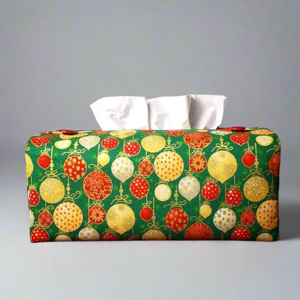 Cotton rectangle tissue box cover with holiday themed red, gold, and white Christmas baubles with metallic gold accent on green background