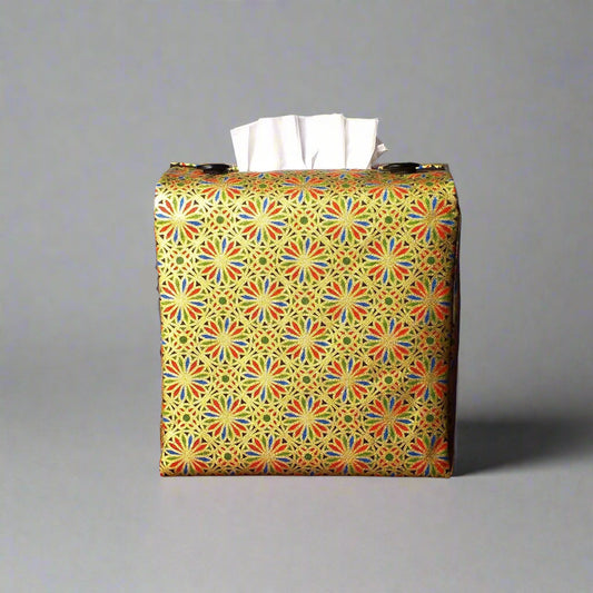 Square tissue box cover with holiday themed blue, red, and green petals, with metallic gold accent