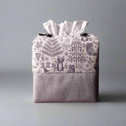 Square tissue box cover with Christmas themed winter forest scene on off-white background, and solid grey base