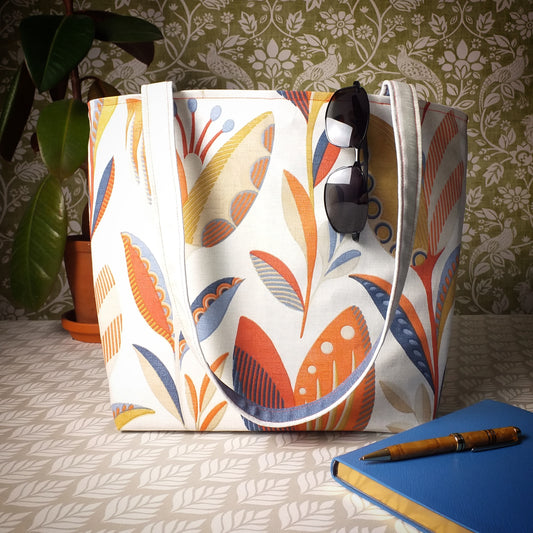 Large tote bag with shades of burnt orange, ochre, and denim blue tulip design on off-white background