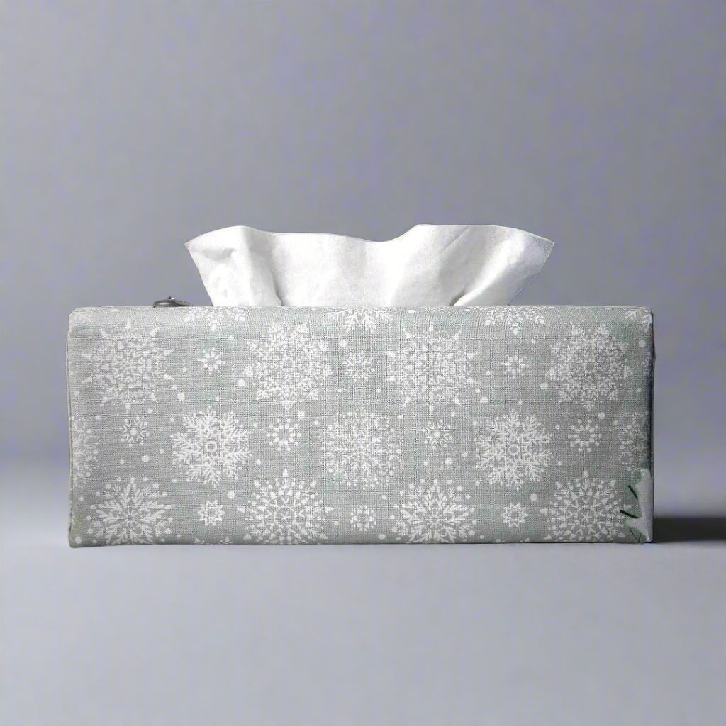 Rectangular tissue box cover with holiday themed white snowflake design on grey background