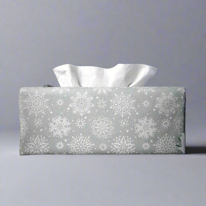 Rectangular tissue box cover with holiday themed white snowflake design on grey background
