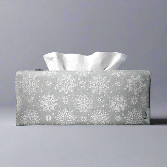 Rectangular tissue box cover with holiday themed white snowflake design on grey background