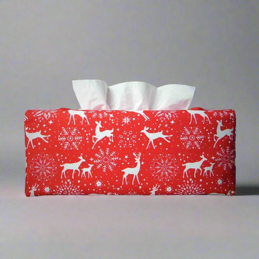 Rectangular tissue box cover with holiday themed white reindeer design on red background