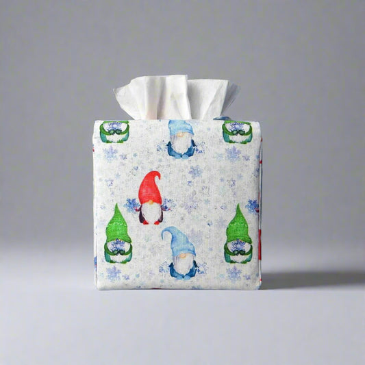 Square tissue box cover with holiday themed red, green, and blue gnomes design on white and blue snowflake pattern background