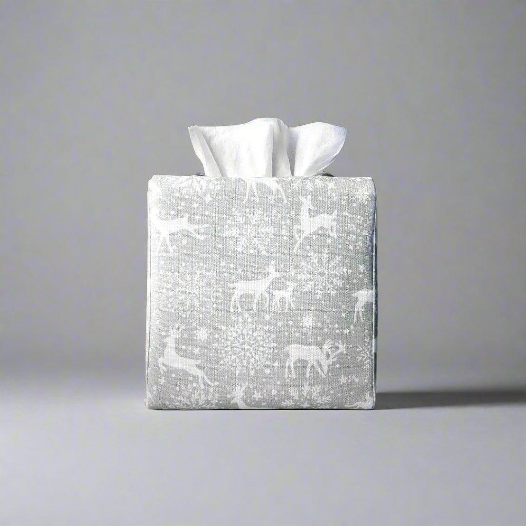 Square tissue box cover with holiday themed white reindeer design on grey background