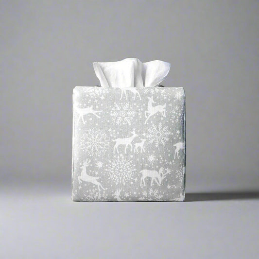 Square tissue box cover with holiday themed white reindeer design on grey background