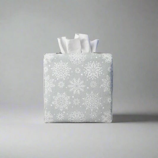 Square tissue box cover with winter themed white snowflakes design on grey background