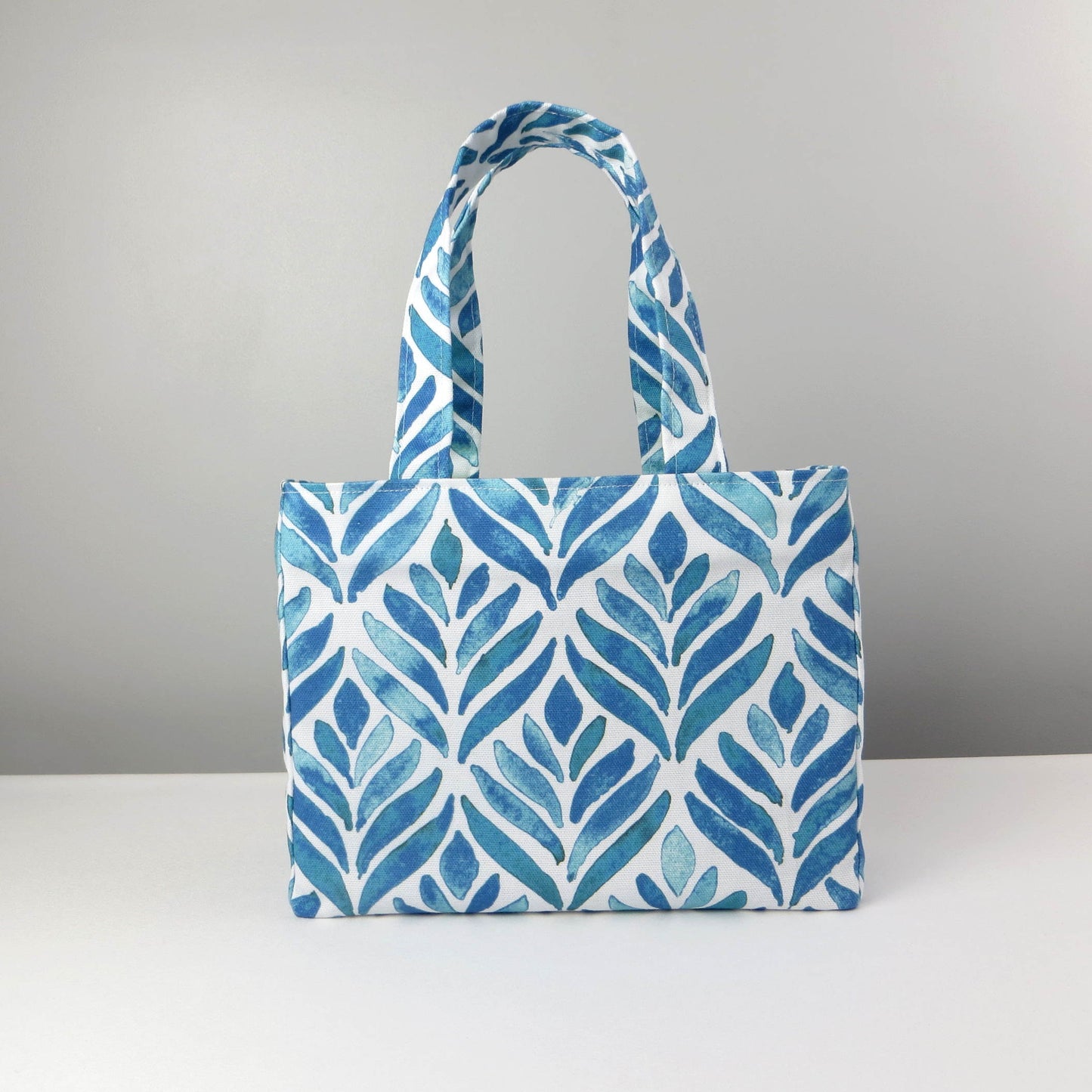 Mini tote bag with blue watercolour style leaf pattern on background