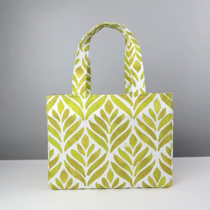 Front view of a mini tote bag with yellow watercolour style leaf pattern on background