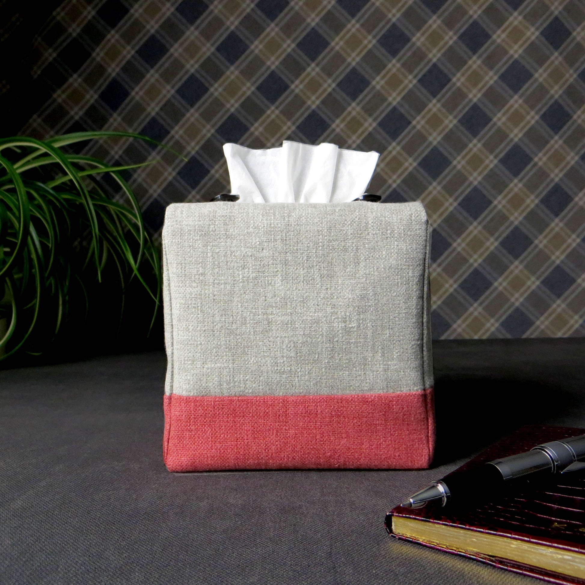 Square tissue box cover with pen, notebook, and plant