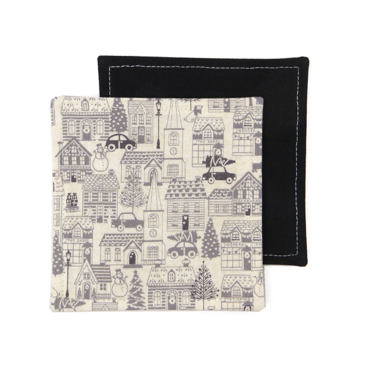 Square coasters with holiday themed winter village scene on off-white background