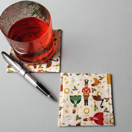 Square coasters with holiday themed multi colour icons of the 12 Days of Christmas on off-white background