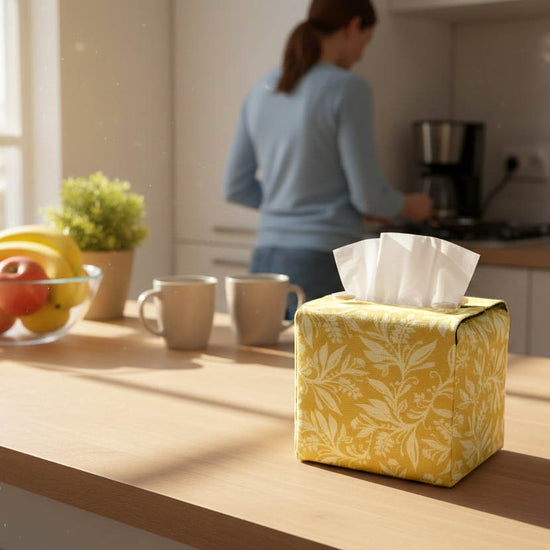 Handmade tissue box cover with yellow floral design displayed in a kitchen