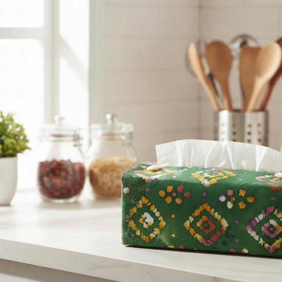 Rectangular tissue box cover with orange diamond design on a green background displayed in a kitchen