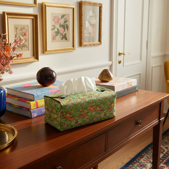 Tissue box cover with birds and berries design on red background displayed in a bedroom and kitchen