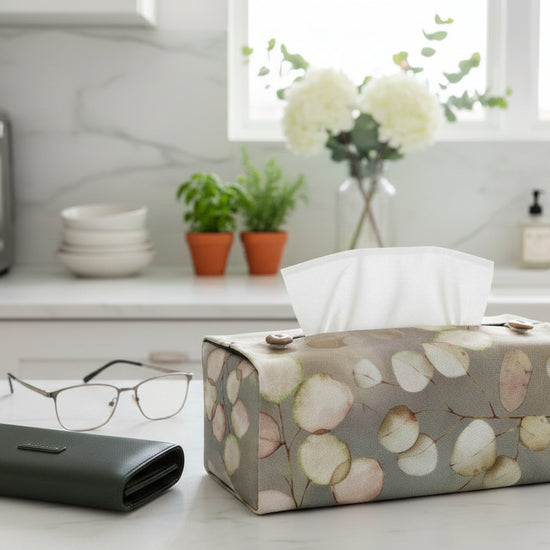 Tissue box cover with lunaria leaves design on brown background displayed in a hallway and kitchen
