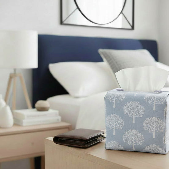 Tissue box cover with white mulberry trees design on blue background displayed in a kitchen and living room