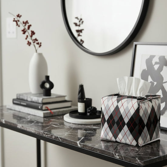 Tissue box cover with black and white Argyle pattern displayed in a home entrance and living room